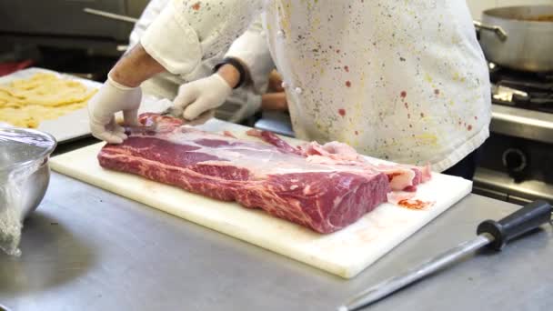 Шеф-повар вырезает мясо для стейков на кухне в Италии, 4K — стоковое видео