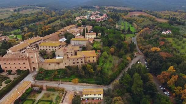 Légi felvétel, egy ősi kisváros található vidéki táj művelt föld és olajfák Toszkánában, Olaszországban, sok lövés a drone — Stock videók