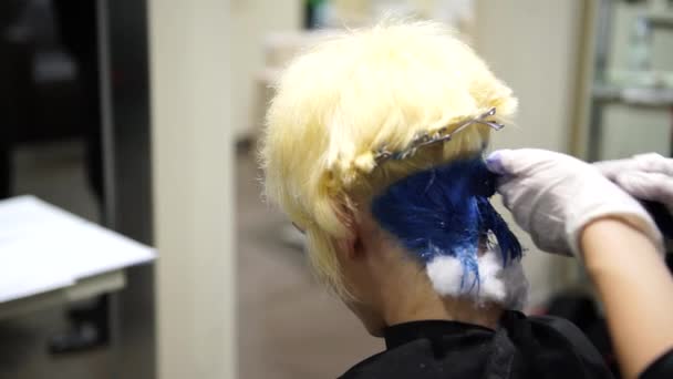 En ung vacker kvinna att få håret färgat i blå hos frisörer, 4k — Stockvideo