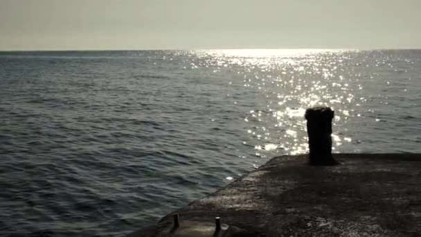 Píer retroiluminado no pôr do sol junto ao mar, câmera lenta HD — Vídeo de Stock