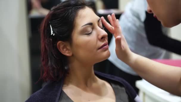 Maquillaje artista que compone una joven hermosa mujer, 4k — Vídeo de stock