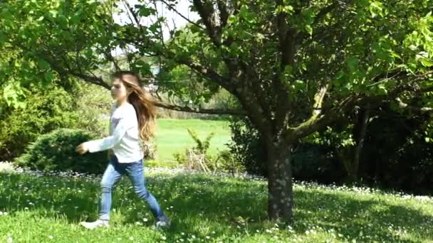 Bambina con lunghi capelli castani che raccoglie un frutto dall'albero, rallentatore HD — Video Stock