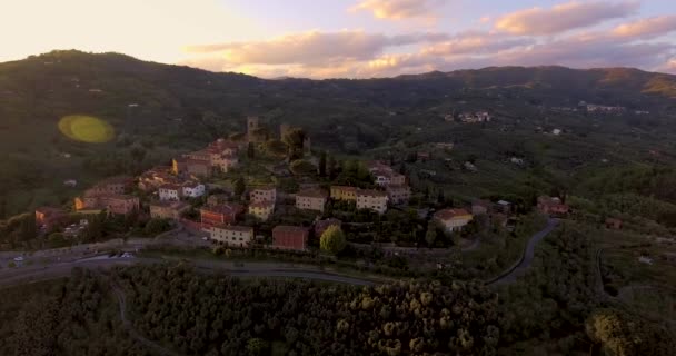 Plano aéreo, una pequeña aldea toscana en la colina en la luz del atardecer en Italia, 4K — Vídeo de stock