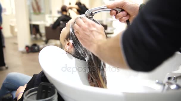 Una joven hermosa mujer que se lava el pelo en los peluqueros, 4K — Vídeos de Stock