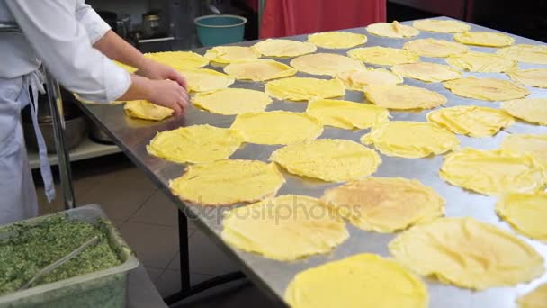 Eine Köchin in der Küche des Catering-Restaurants legt ein paar Pfannkuchen oder Crêpes nieder, bevor sie sie mit der Füllung auffüllt, 4k — Stockvideo