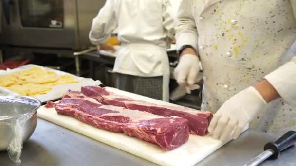 Een chef-kok het vlees voor de steaks in zijn keuken in Italië, 4k snijwerk — Stockvideo