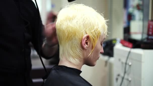 Eine junge schöne Frau bekommt ihre blonden Haare beim Friseur getrocknet, 4k — Stockvideo