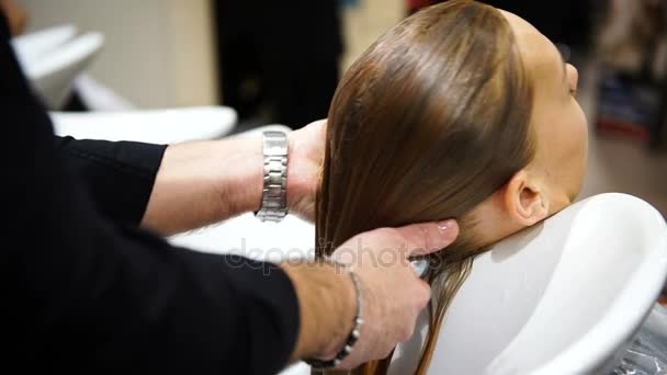 Молода красива жінка вимиває волосся у перукарів, 4K — стокове відео