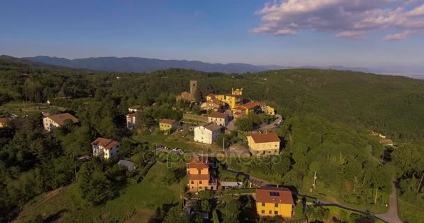 Imágenes aéreas de un pequeño pueblo entre verdes colinas y paisaje llano en Toscana, Italia, 4K — Vídeos de Stock