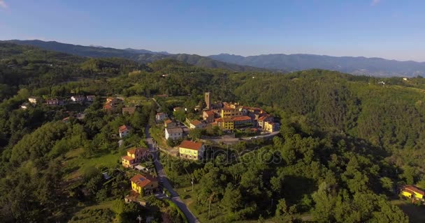 Imágenes aéreas de un pequeño pueblo entre verdes colinas y paisaje llano en Toscana, Italia, 4K — Vídeos de Stock