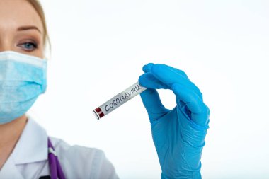A nurse s hand in a glove holds a test tube with the inscription COVID 19, with a positive blood test for a new rapidly spreading coronavirus, close-up, shallow depth of field, selective focus
