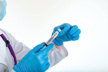 A nurse s hand in a glove holds a test tube with the inscription COVID 19, with a positive blood test for a new rapidly spreading coronavirus, close-up, shallow depth of field, selective focus
