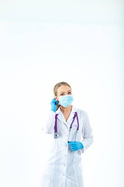 Doktor hemşire koruyucu bir maske takıyor. Solunum maskeli bir hemşire. Maske takın. Eldiven tak.