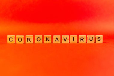 Salgın hastalık ve virüs kavramı ahşap harflerden oluşan bir Coronavirus sözcüğüdür. Kırmızı arka planda Coronavirus metni. covid19
