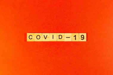 Salgın hastalık ve virüs kavramı ahşap harflerden oluşan bir Coronavirus sözcüğüdür. Kırmızı arka planda Coronavirus metni. covid19