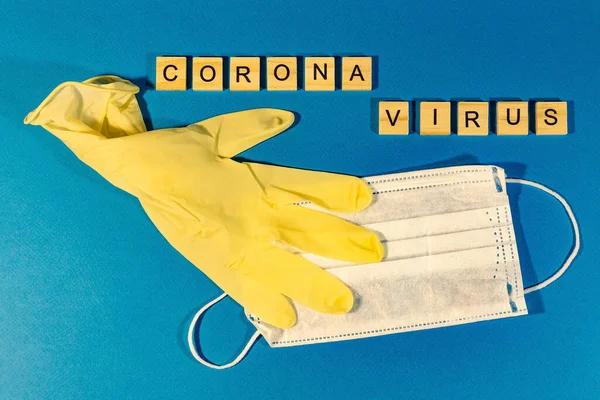 A medical mask, medical gloves on the blue surface. Concept coronavirus, flu, infection, epidemic. View from above. horizontal orientation. View from above.