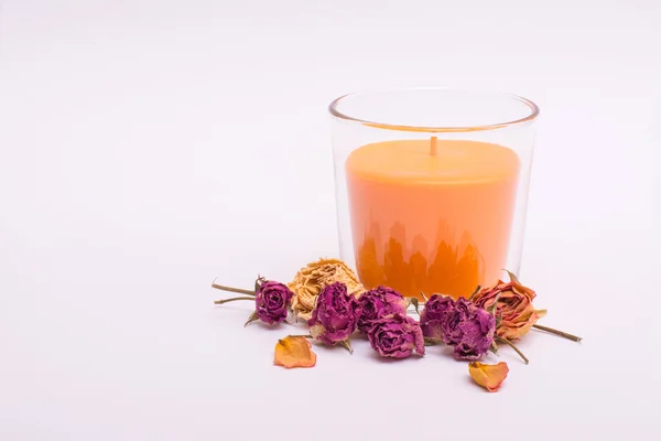 Orangenkerze in einem Glas mit trockenen Blumen. isolieren auf weißem Hintergrund lizenzfreie Stockfotos