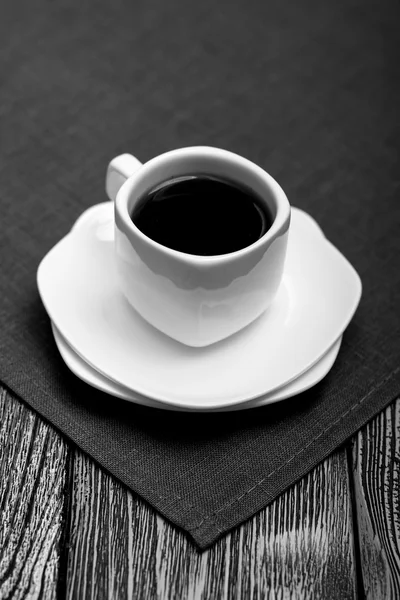 Küçük beyaz fincan kahve ahşap arka plan üzerinde kumaş üzerine. Siyah ve beyaz — Stok fotoğraf