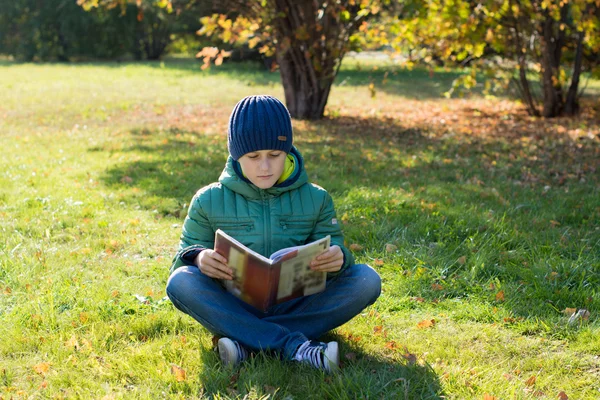 Libro de lectura de niño en otoño Park — Foto de Stock