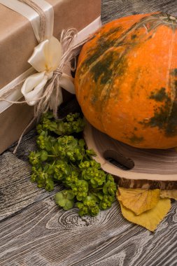 ağaç, hediye kutusu ve sarı kesme üzerinde kabak ahşap arka plan üzerinde bırakır. Cadılar Bayramı kompozisyon