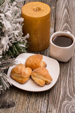 Fincan kahve, kurabiye, mum, ahşap arka plan üzerinde kar köknar dalı