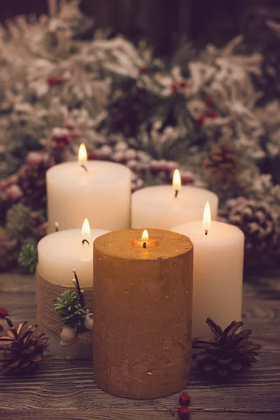 Ramo di abete nella neve, candela accesa, cono su fondo di legno. Tema di Natale — Foto Stock