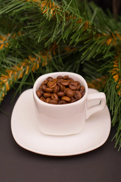 Kaffeebohnen in einer weißen Tasse und Tannenzweig — Stockfoto