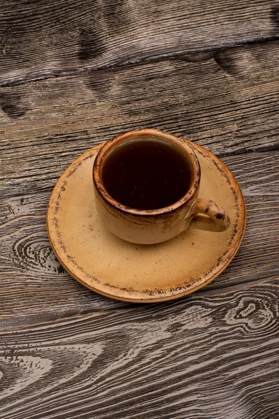 Small cup of coffee on wooden background — Stock Photo, Image