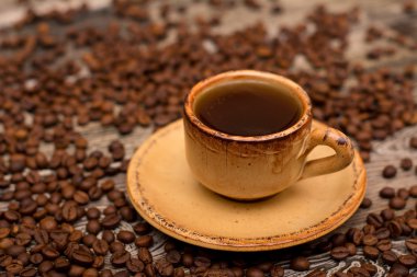 Küçük ahşap arka plan üzerinde kahve, kavrulmuş kahve çekirdekleri fincan