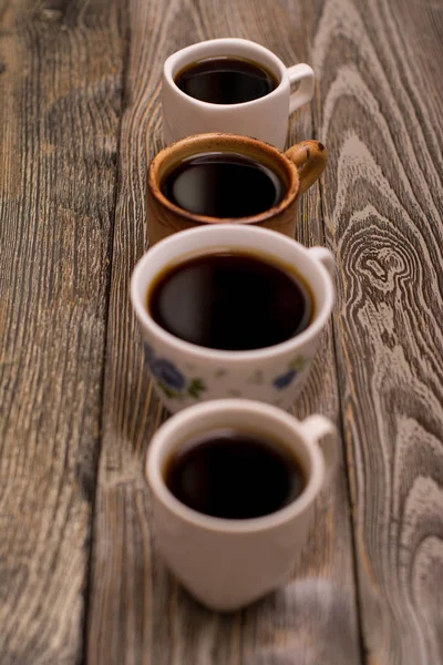 Dört fincan kahve ahşap arka plan üzerinde — Stok fotoğraf