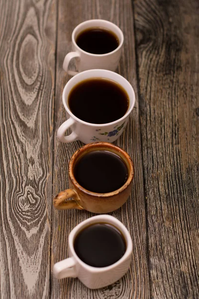 Dört fincan kahve ahşap arka plan üzerinde — Stok fotoğraf