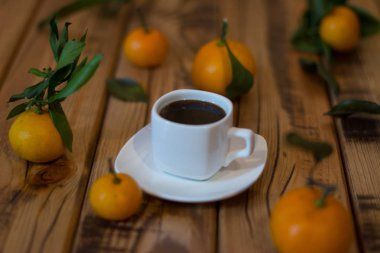 Küçük beyaz fincan kahve ve ahşap zemin üzerine mandalina