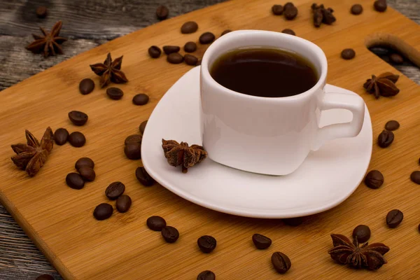 Kis fehér csésze kávé, csillag ánizs, fából készült háttér — Stock Fotó