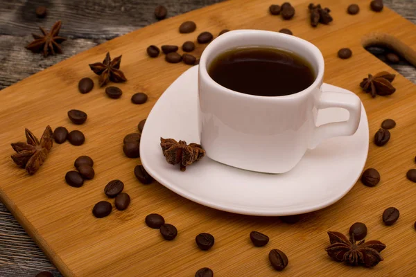 Small white cup of coffee, star anise on wooden background — Stock Photo, Image