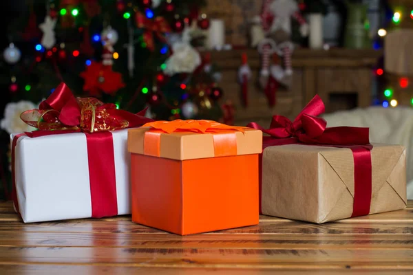 Tres cajas de regalo sobre mesa de madera contra fondo de luces —  Fotos de Stock