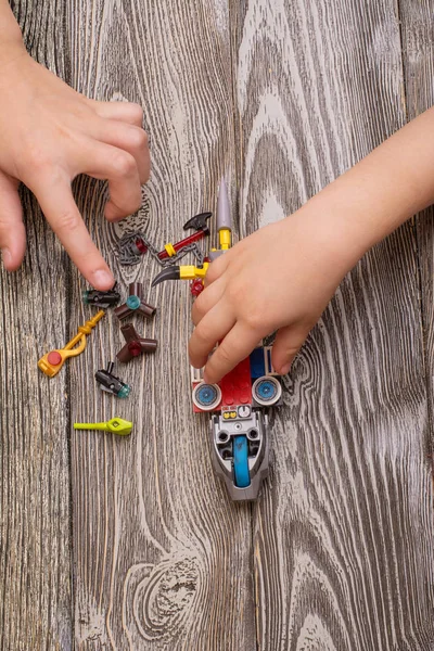 Ein Kind spielt mit Plastikbausteinen oder Ziegelspielzeug Stockbild