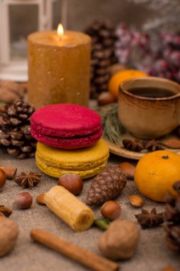 Fincan kahve, bademli kurabiye, kurabiye, ceviz, fındık, tarçın, yıldız anason, koni, mum, köknar dalı çul kumaş üzerine