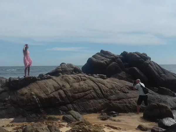 Menina em um vestido rosa e um fotógrafo à beira-mar — Fotografia de Stock