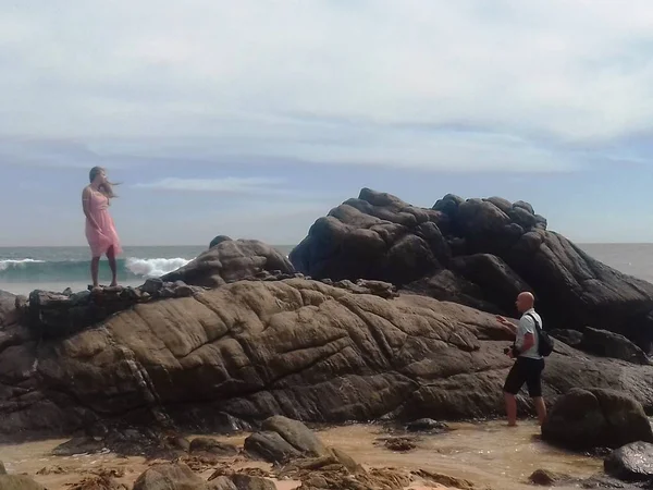 Menina em um vestido rosa e um fotógrafo à beira-mar — Fotografia de Stock