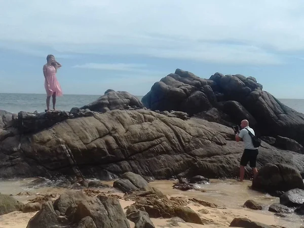 Menina em um vestido rosa e um fotógrafo à beira-mar — Fotografia de Stock