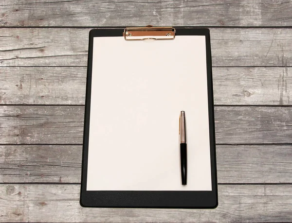 Une feuille blanche de papier avec stylo sur une table en bois en carton — Photo