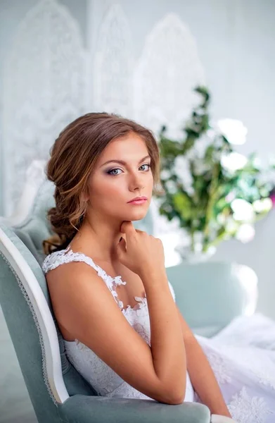 Bella, sposa gentile in abito da sposa bianco in camera luminosa di lusso — Foto Stock