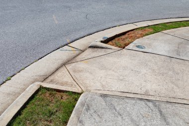 Asfalt sokak ve beton kaldırım arasında derecelendirilmiş rampa, yeşil çimen, yatay görünüm