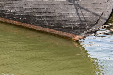 Eski ahşap bir geminin siyah gövdesinin ayrıntıları, yeşil deniz suyu kopyalama alanı, yatay görünüm