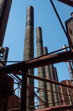 Duman bacaları ve kirişlerin bileşimi, borular ve kirişler, mavi gökyüzü ile güneşli bir gün, dikey görünüm
