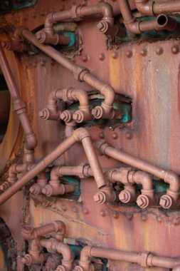 Paslanmış ve paslanmış boru ve bağlantı ağı, alışılmadık endüstriyel arka plan, dikey görünüm