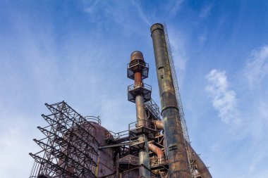 Büyük endüstriyel çelik fabrikasının altından muazzam bir manzara, terk edilmiş tesis, mavi gökyüzü, yatay görünüm