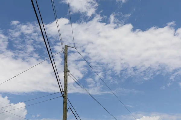带有传输线的单根木电线杆在蓝天和云彩的映衬下向三个方向辐射 具有创意的复制空间 水平方向 — 图库照片