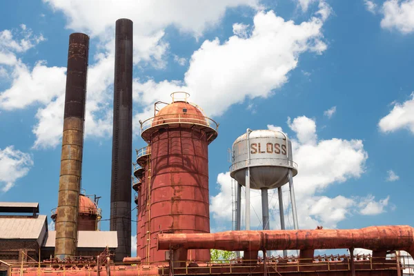 Sloss Furnaces Ulusal Tarihi Eserler, Birmingham Alabama USA, su kulesi, fırınlar ve duman yığınları, bulutlu mavi gökyüzü