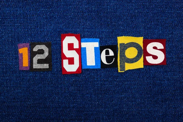 12 STEPS kelime kolajı, mavi kot üzerine çok renkli kumaş, bağımlılık ve düzelme konsepti, yatay görünüm